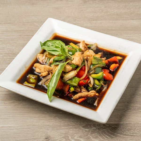 Thai chicken stir-fry with colorful vegetables and basil in a rich brown sauce.