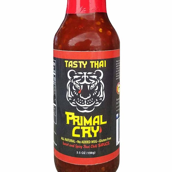 A bottle of Tasty Thai Primal Cry Sweet and Spicy Thai Chili Sauce with a tiger logo.