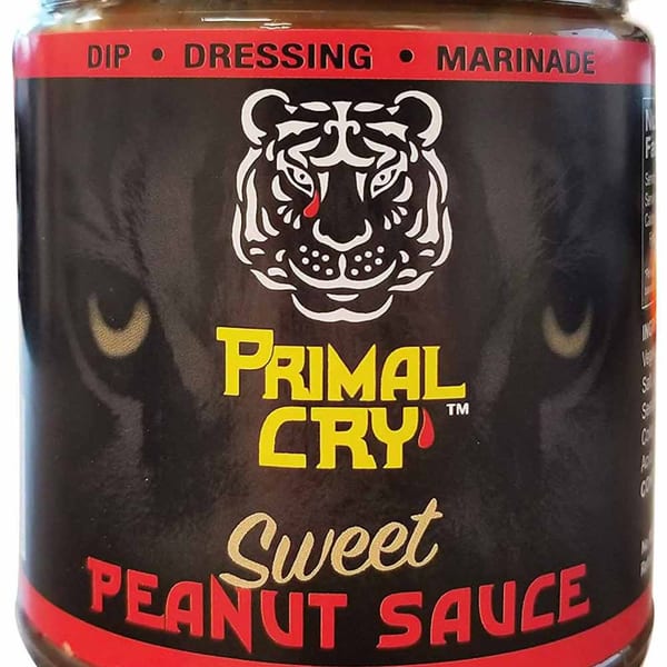 Close-up of a Primal Cry Sweet Peanut Sauce jar with a tiger logo.